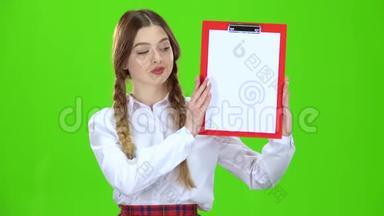 女孩用<strong>纸举</strong>起一块红色的平板电脑。 绿色屏幕